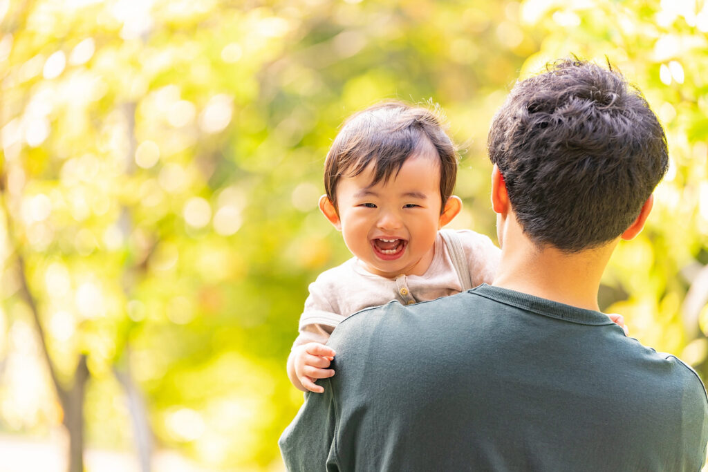 父親に抱っこされる男の子（笑顔）