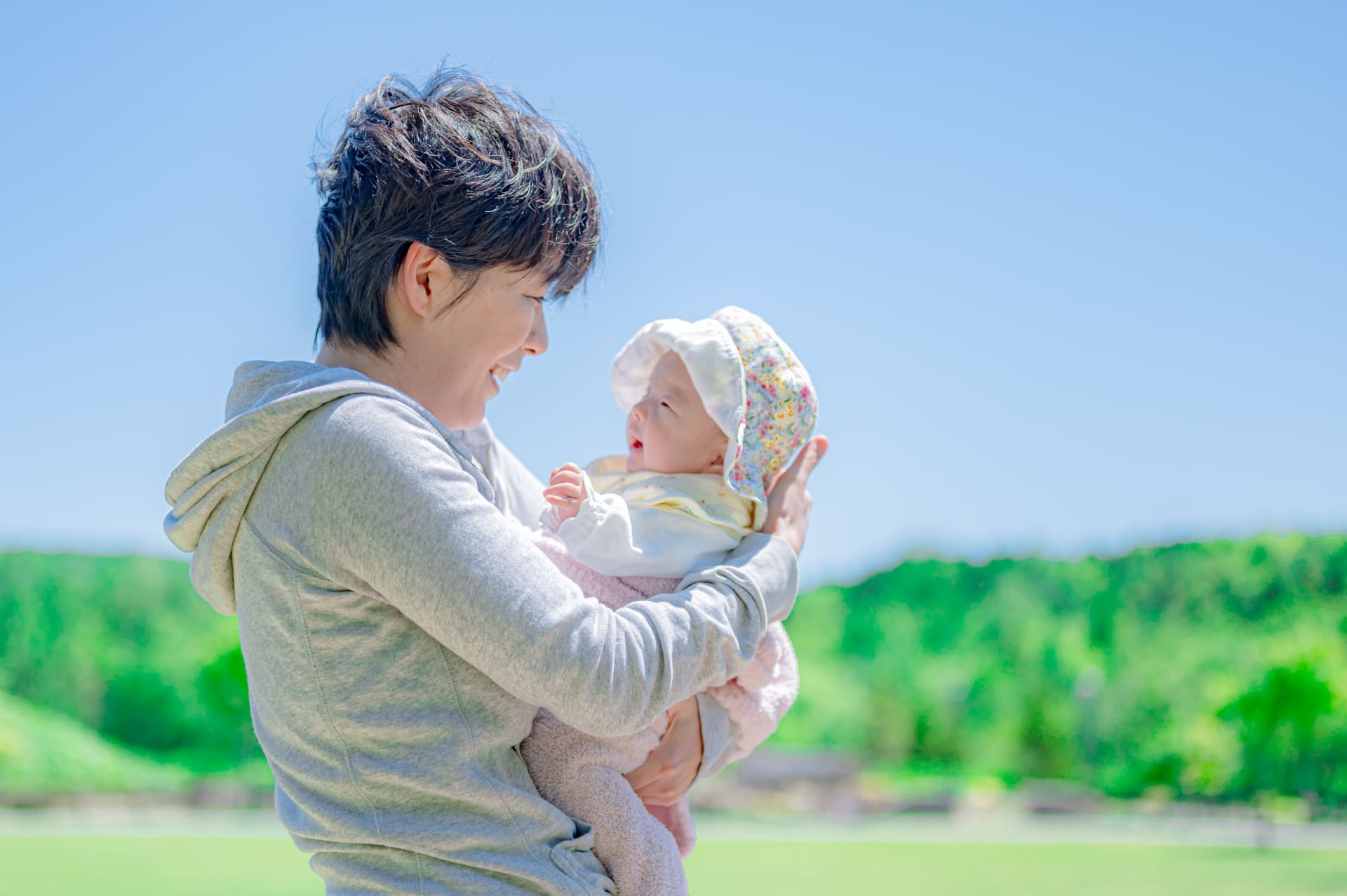 屋外で赤ちゃんを抱く女性