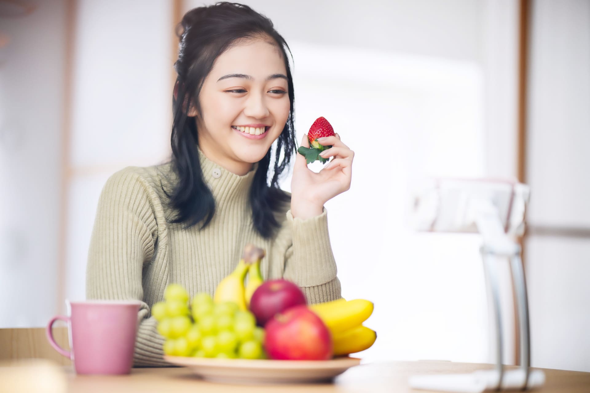 いちごを持ち喜ぶ女性