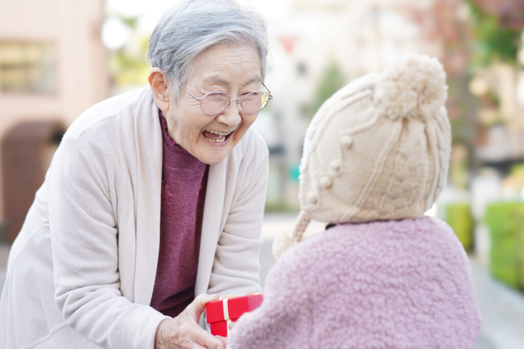 おばあちゃんにプレゼントを渡す孫の後ろ姿 (1)