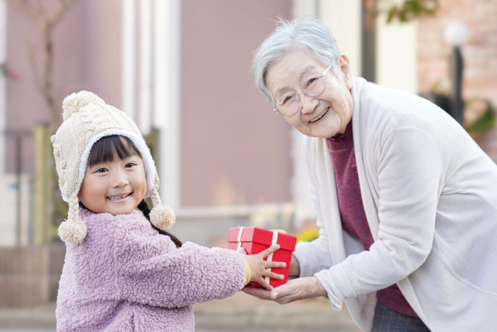 おばあちゃんにプレゼントを渡す女の子の記念撮影